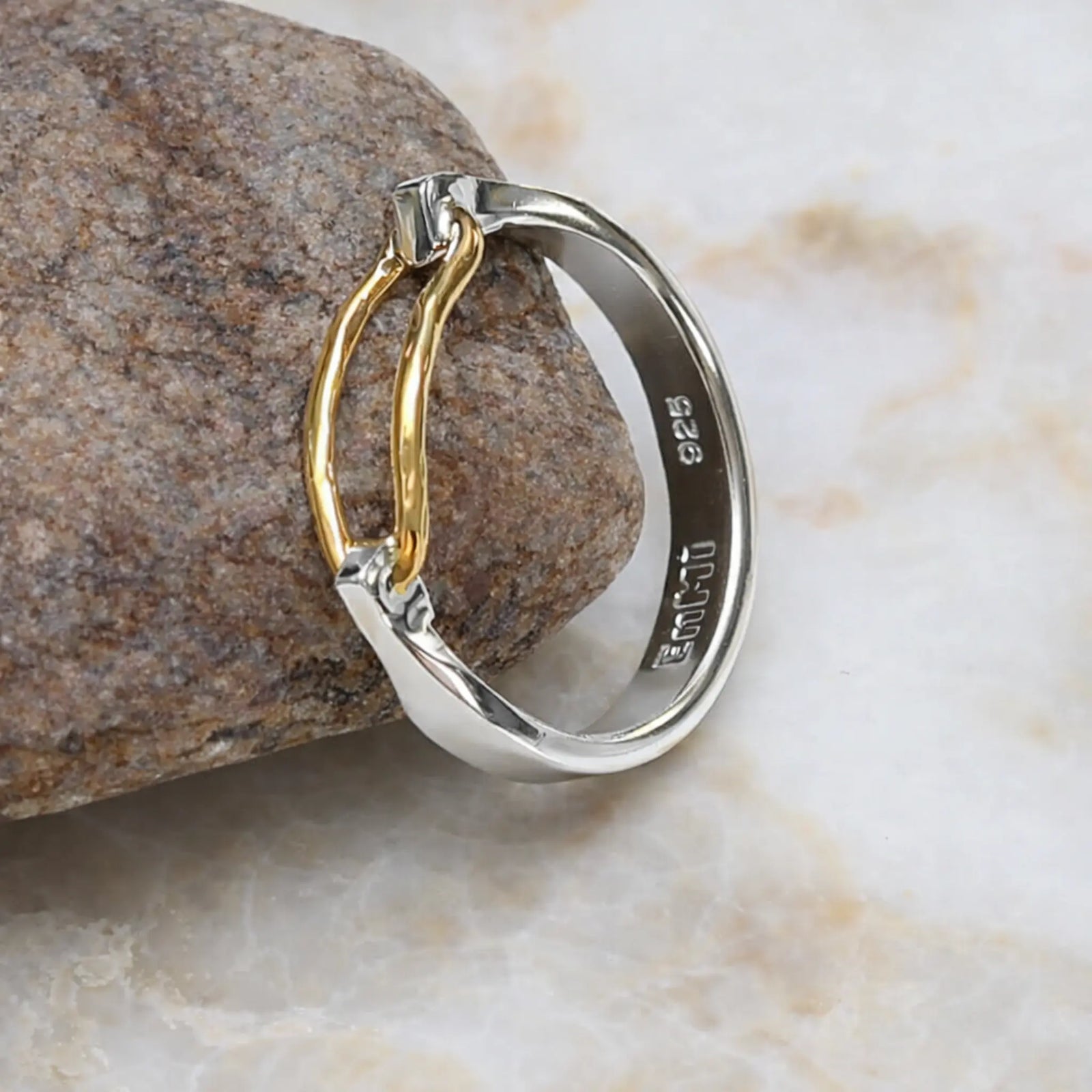 Two-toned ring with gold and silver on a stone surface