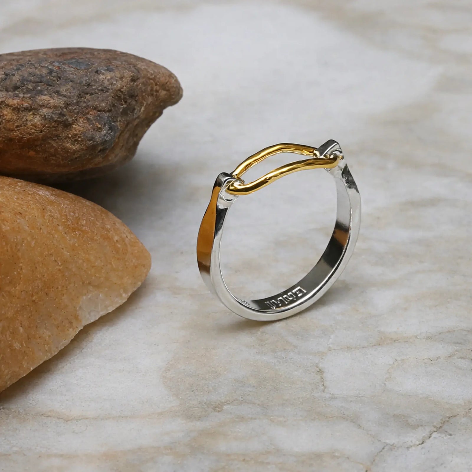 Two-toned ring with gold and silver on a stone surface