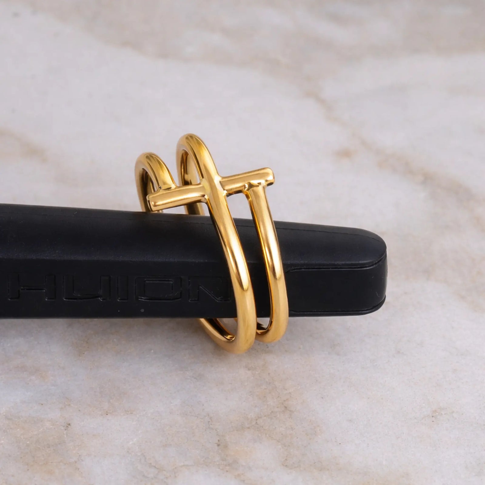 Gold ring with a unique design on a marble surface