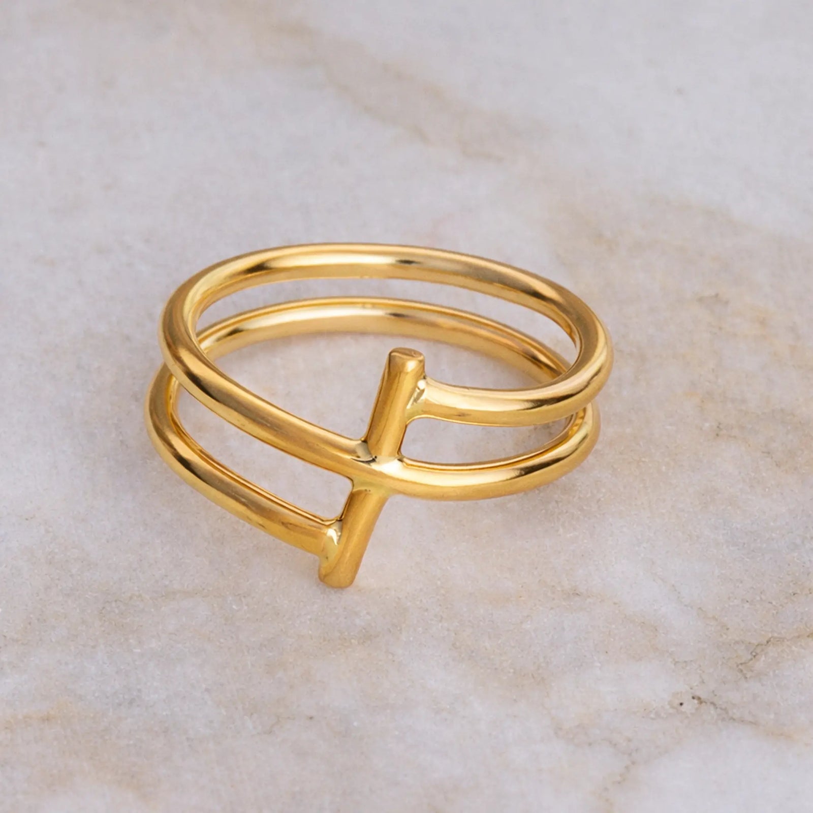Gold ring with a unique design on a marble surface